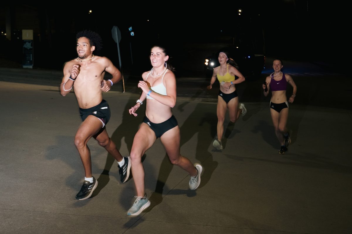 Runners sprint through the February night wearing the safety glow necklaces for the Nearly Naked Mile Run. 
