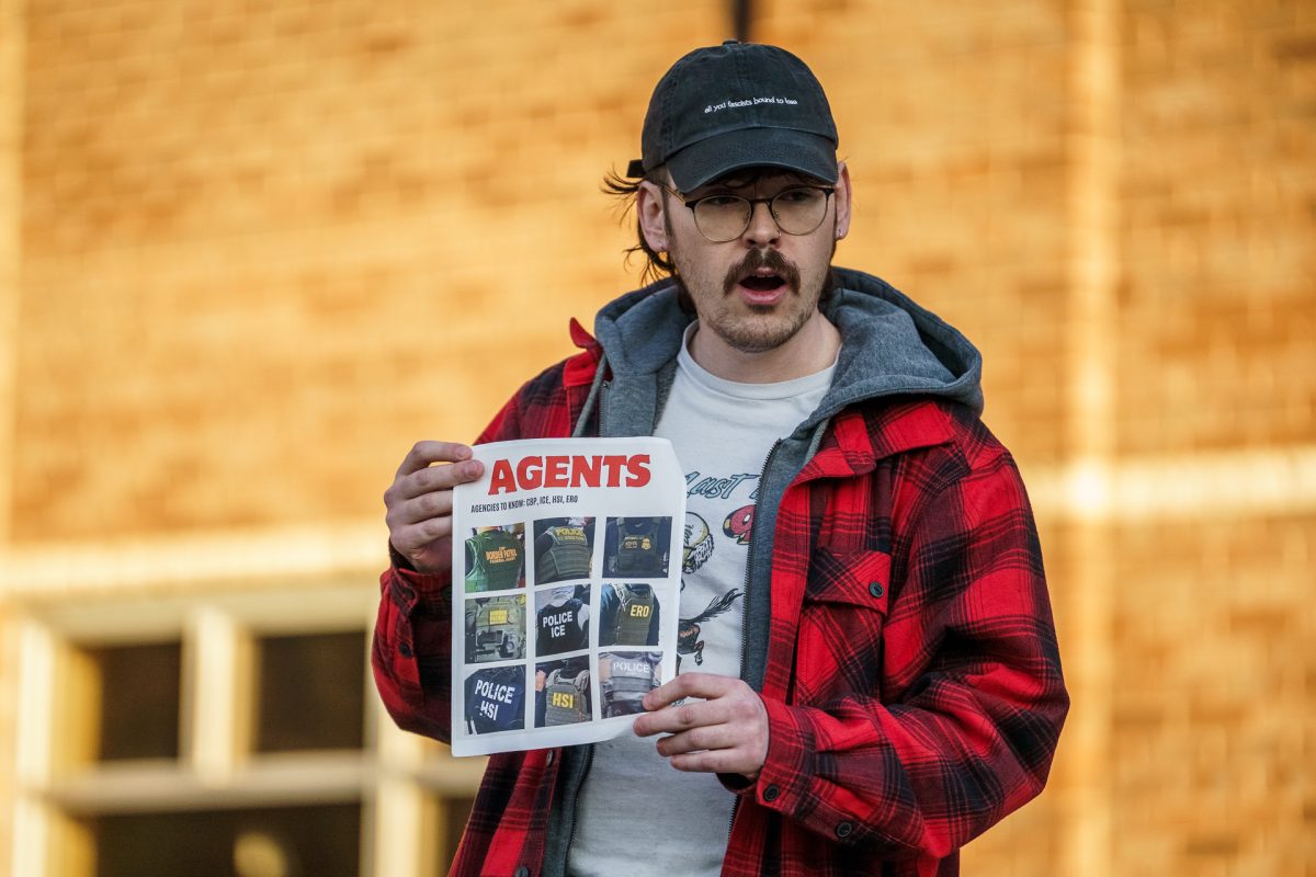 Chayton Hall, president of UNCA College Democrats gives a speech to students while holding a paper showing how to identify ICE agents.
