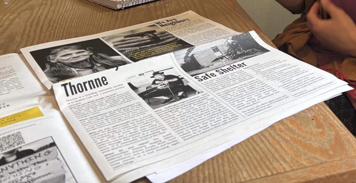 The Asheville Poverty Initiative shows off its new street paper, created to assist those facing homelessness in finding resources.
