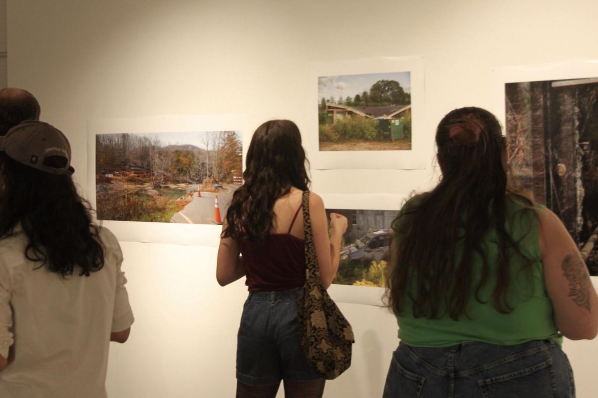 Attending students look at Natalie Akins’ photography at her solo BFA exhibition.